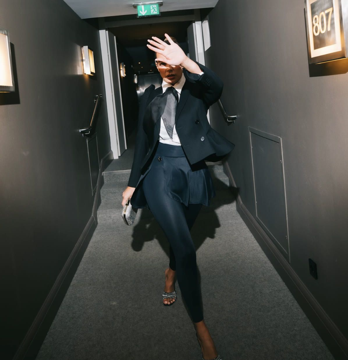 Nadine Mirada in a navy suit, hotel corridor